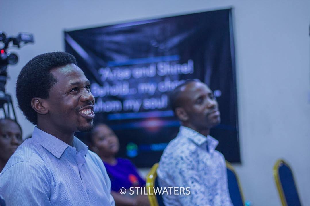Two men in the congregation look up with inspired, smiling expressions during a Stillwaters Ministries conference.